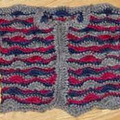 A striped crocheted baby sweater.