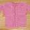 A crocheted doll's sweater in pink.