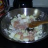 Chicken being stir fried in a wok.