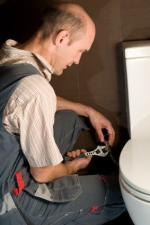 Man installing a toilet.