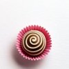 Chocolate truffle with spiral design in pink paper cup.