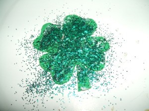 Gluing glitter to shamrock.
