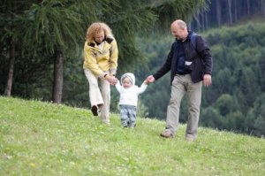 Mother and Father Helping Child with First Steps