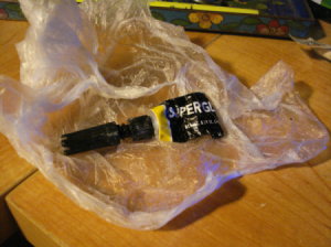 Tube of Super glue that has been stored in plastic wrap.