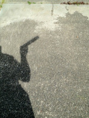 Shadow of man holding pinhole viewer.