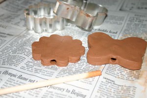Using dowel to make hole in clay.