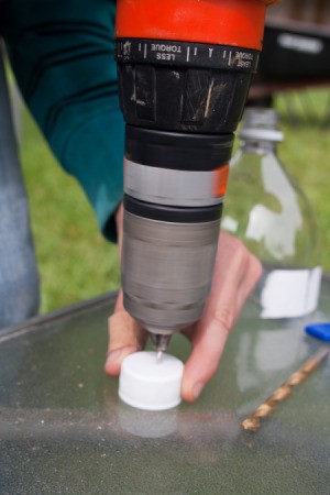 Drilling a hole through a bottle cap.