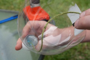 Run string wick through hold in cap to water plants.