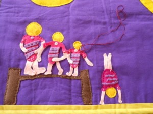 Close up of gymnasts while sewing onto rug.
