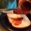 Homemade raspberry jam being spread on a piece of bread