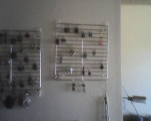 Jewelry hanging from racks, mounted on wall.