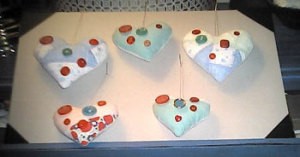 Pieced heart shaped ornaments decorated with buttons. 