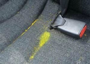 Photo of melted yellow crayon on a car seat.