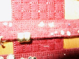 Closeup of cross stitch pattern and some earrings mounted to plastic canvas.