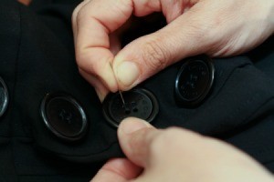 Closeup of Sewing Buttons On Clothing