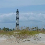 Beach with lighthouse in the distance.