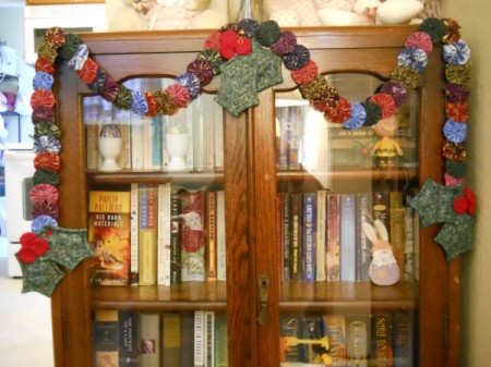 Garland hanging draped on antique wooden bookcase.