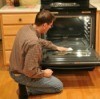 Man Cleaning Glass Oven Door