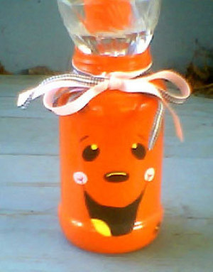 Halloween candle centerpiece made from jar painted like a jack-o-lantern.