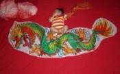 Baby lying on red background with dragon banner.
