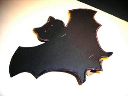 Black bat with wings spread.