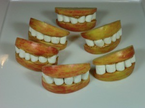 Halloween treat made with apple slices and marshmallows made to look like lips and teeth.