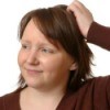 Woman scratching her dry scalp.