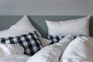A bed with pillows and a comforter