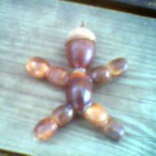 Man shaped decoration made from acorns.