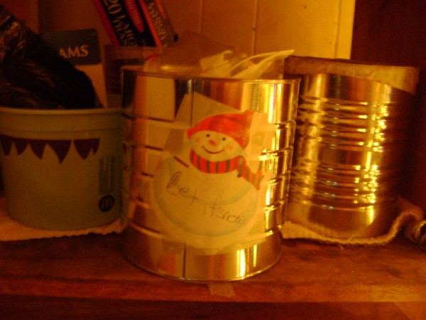 Coffee can with a colorful snowman taped on.