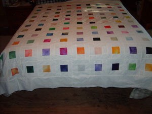 Quilt on bed.