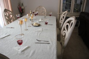 Dining table and chairs with window to left and couch to right.