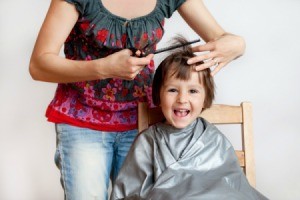 Mother cutting the her child's hair