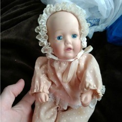 A porcelain baby doll by Dynasty Dolls