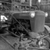 An old tractor in a wooden barn, in black and white