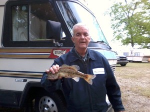 photo of man holding a fish he caught