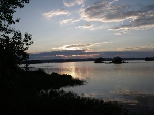 The sun setting over a beautiful lake.