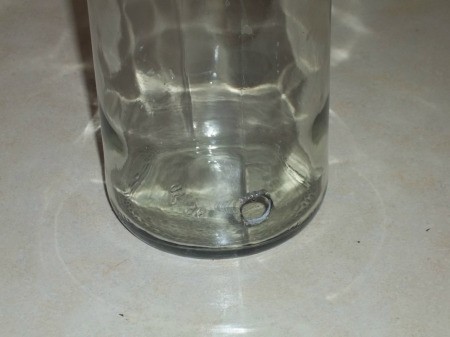Glass bottle with a hole in the bottom.