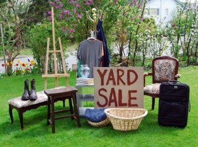 A yard sale with lots of household goods for sale.