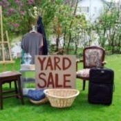 A yard sale with lots of household goods for sale.