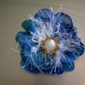 A blue silk flower pin with a pearl center