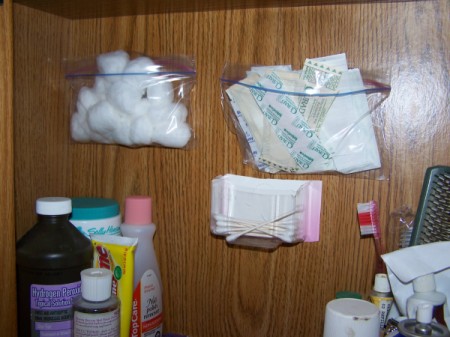 Use plastic baggies to store small items on a bathroom wall.