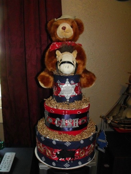 A cowboy themed diaper cake for a baby shower, in red and blue.