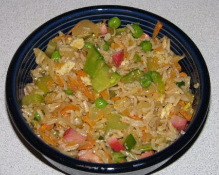 A bowl of homemade fried rice with pork and veggies.