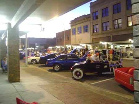 A line of classic cars on a city street.