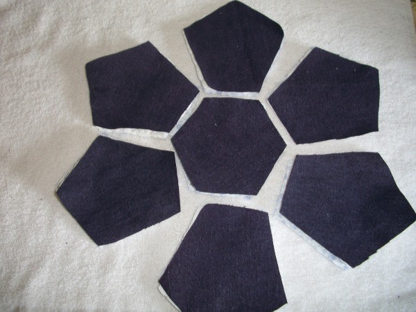 Seven fabric pieces placed in a flower shape in preparation for sewing.