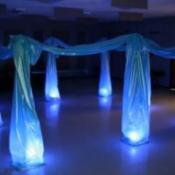 Dance floor with blue lights and draped material forming a canopy over the floor lights.