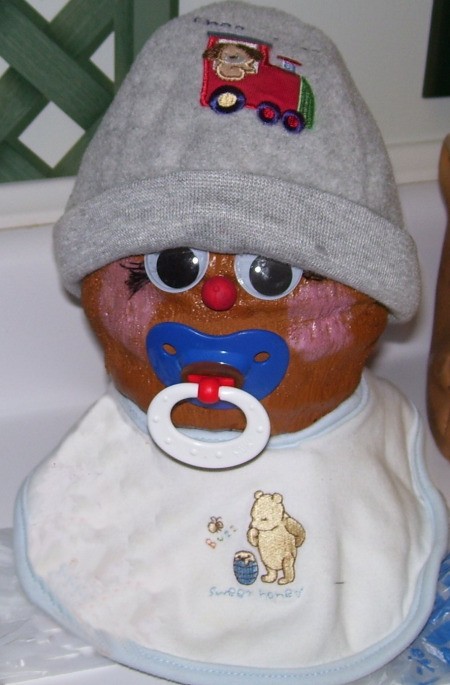 coconut with baby hat, bib, and pacifier