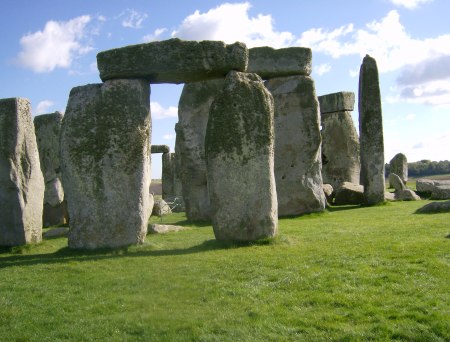 The ancient site of Stonehenge with a cloudy blue sky.