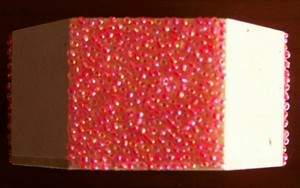view of one side of box covered with pink seed beads